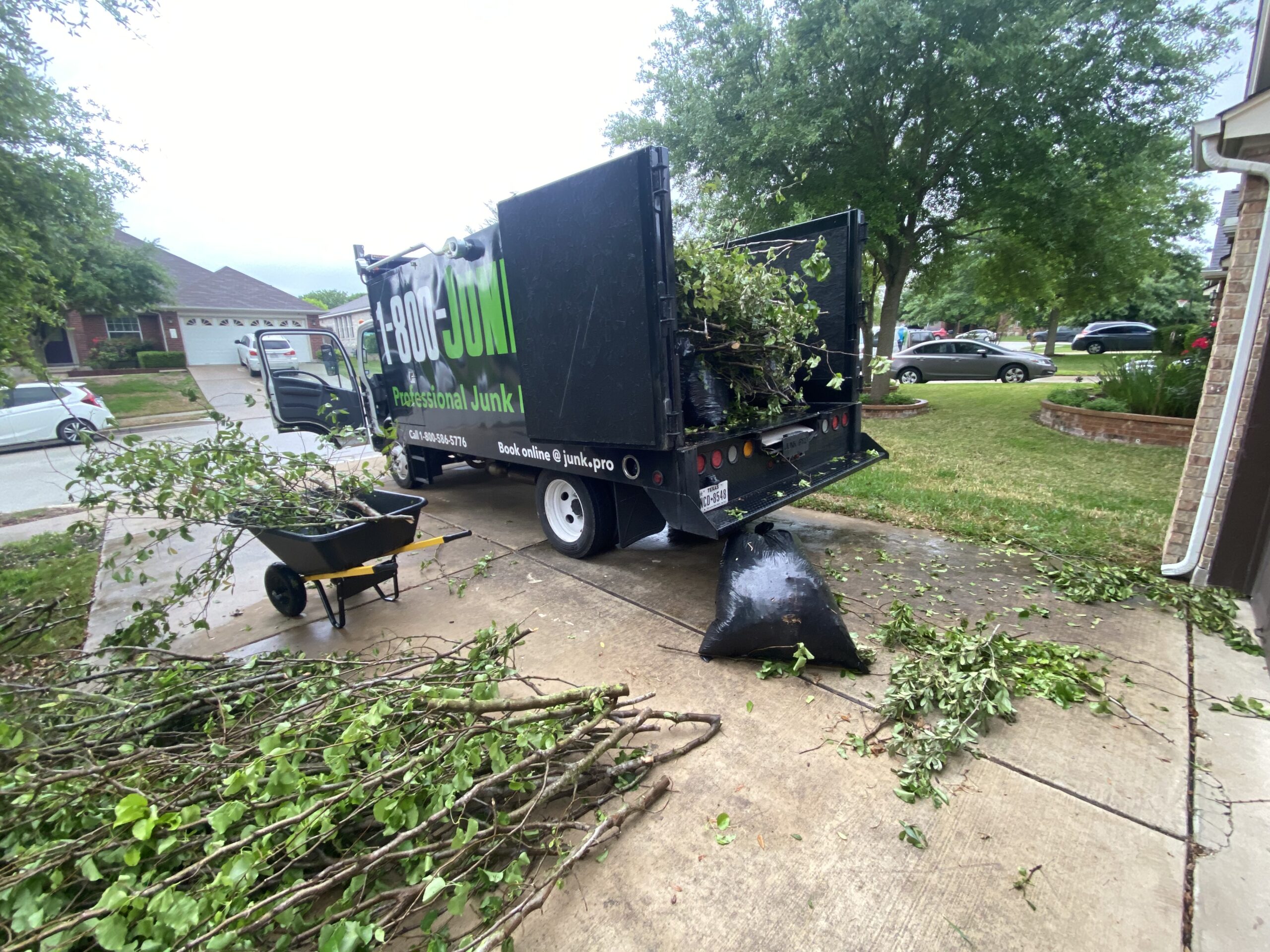 A home with downed trees and storm damage debris