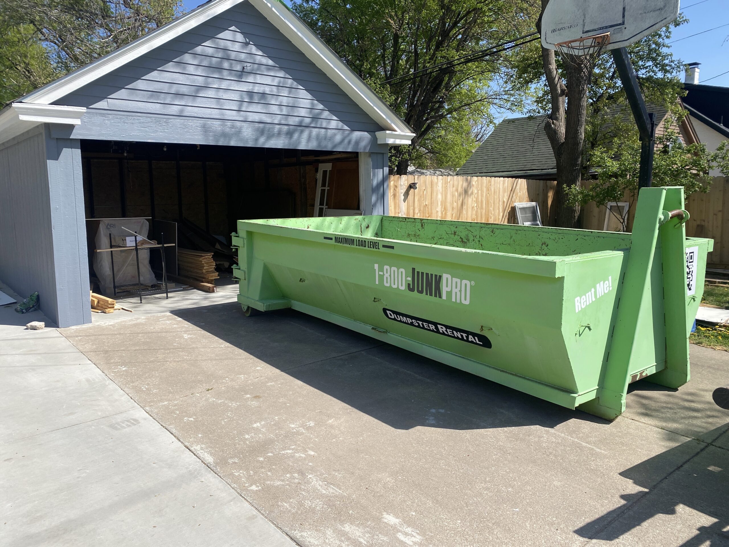 A Dumpster in a Residential Driveway in front of a garage